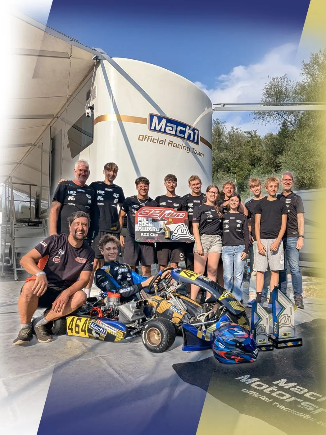 Das Mach1 Rennteam vor dem Mach1 Truck im Fahrerlager, vorn ein Fahrer im Kart